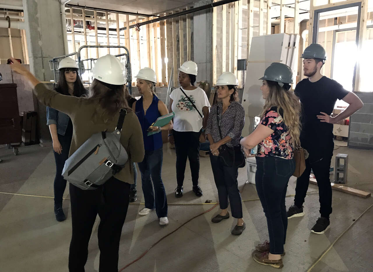 Students touring a construction site with a Dimit Architects representative